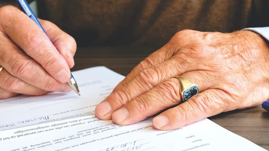 Image of a person holding a retirement plan document with a pen in hand