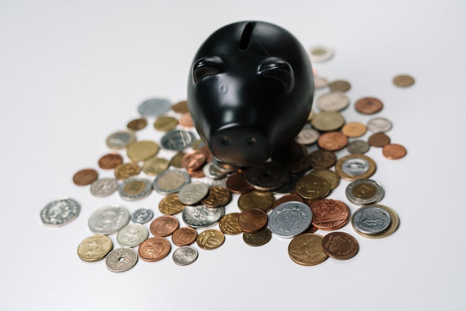 A piggy bank being filled with coins next to a calculator and a dollar sign. This image represents saving money and growing your wealth through high-yield savings accounts.
