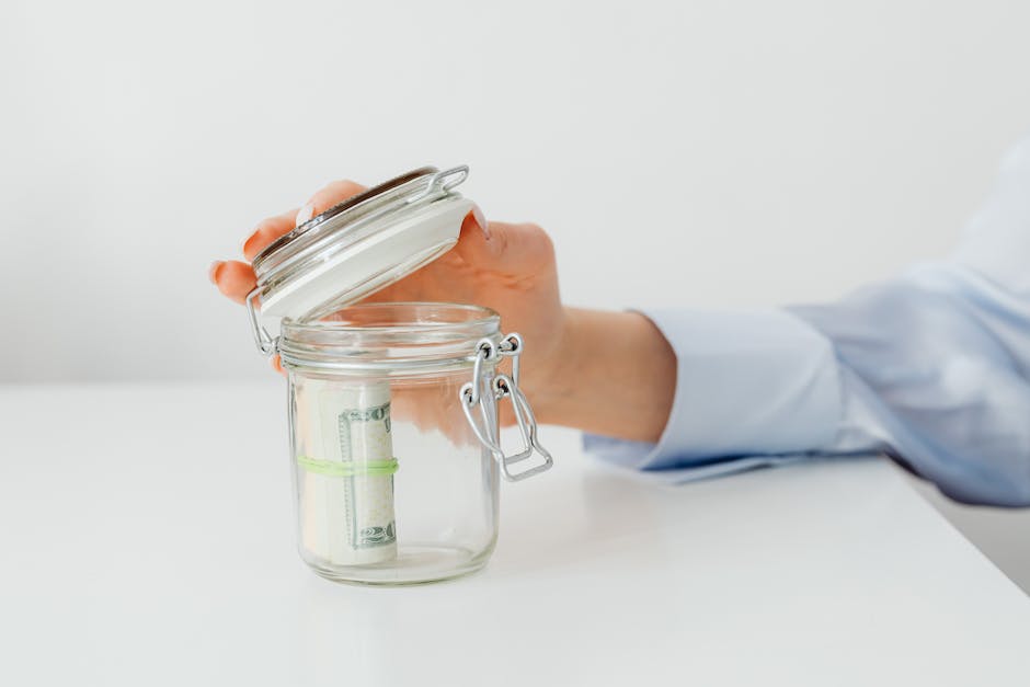Image description: A person holding a retirement savings jar with money inside.